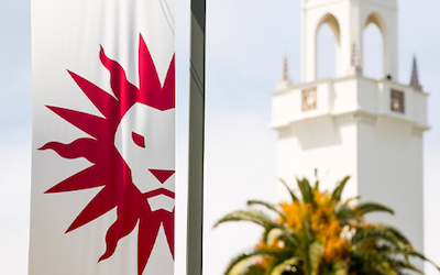Spirit Mark banner with Sacred Heart Chapel tower and palm tree in the background